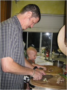 Photo of JM Bray Teaching his 2 year old grandson some kitchen skills